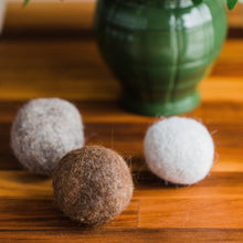 Load image into Gallery viewer, Zero waste fleece alpaca dryer balls in front of green plant. Knoxville, Tennessee. 
